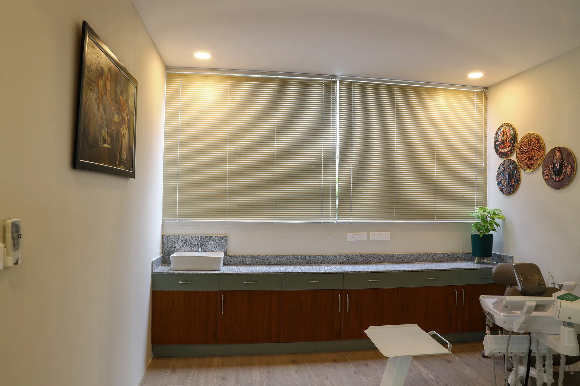 A treatment room counter with framed art and decorative wall plates