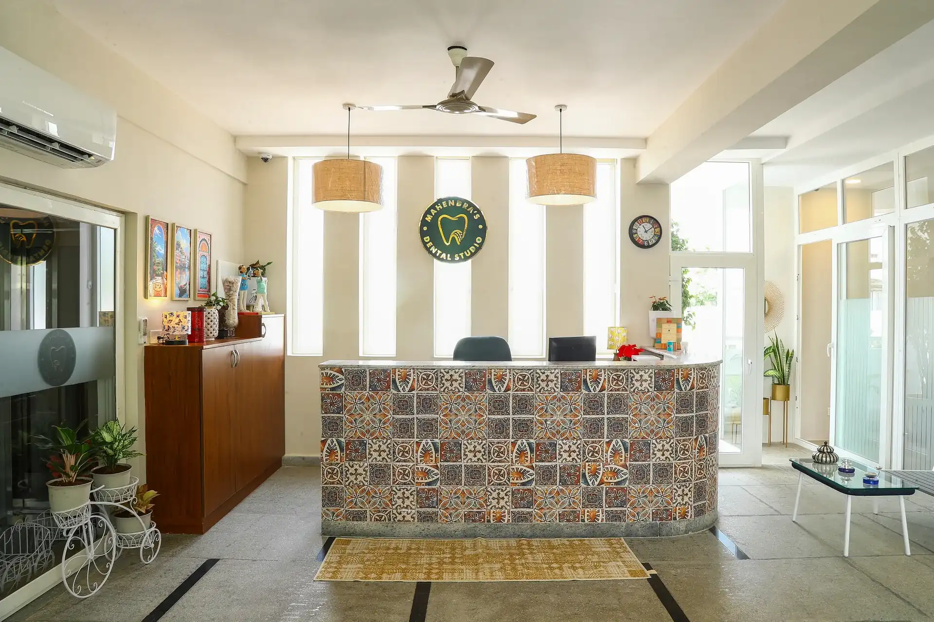 The reception desk at Mahendra's Dental Studio, with a patterned tile front and pendant lights