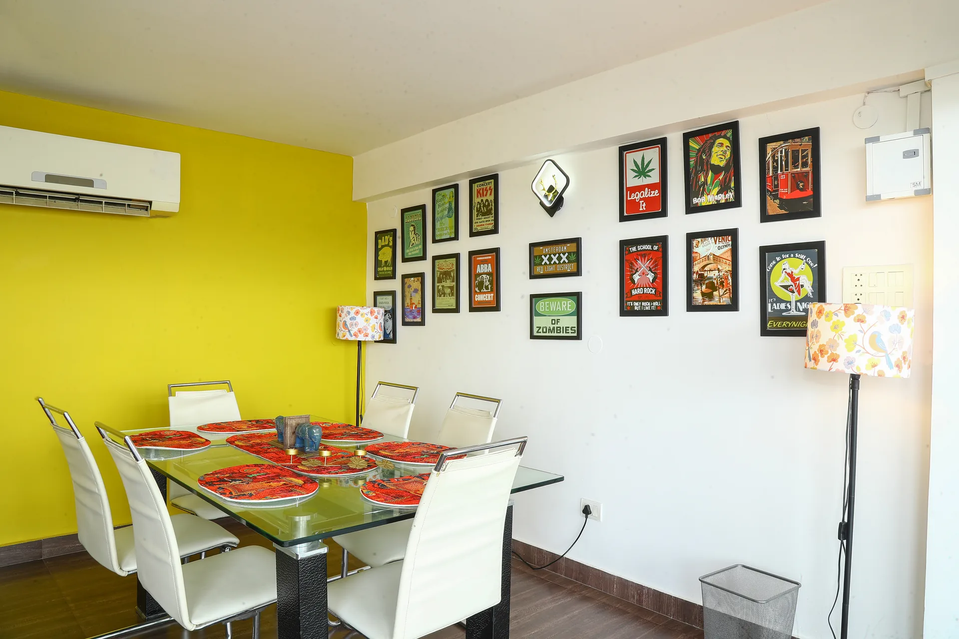 A meeting table beside a yellow wall hung with framed pictures