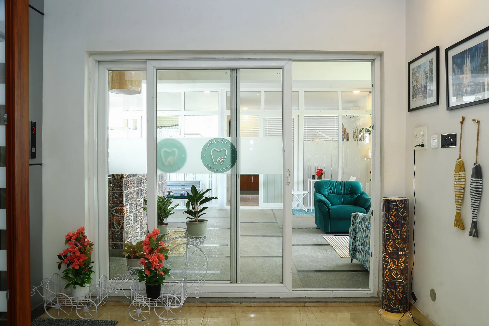 A view through glass doors into the lounge, with flowering plants at the entrance